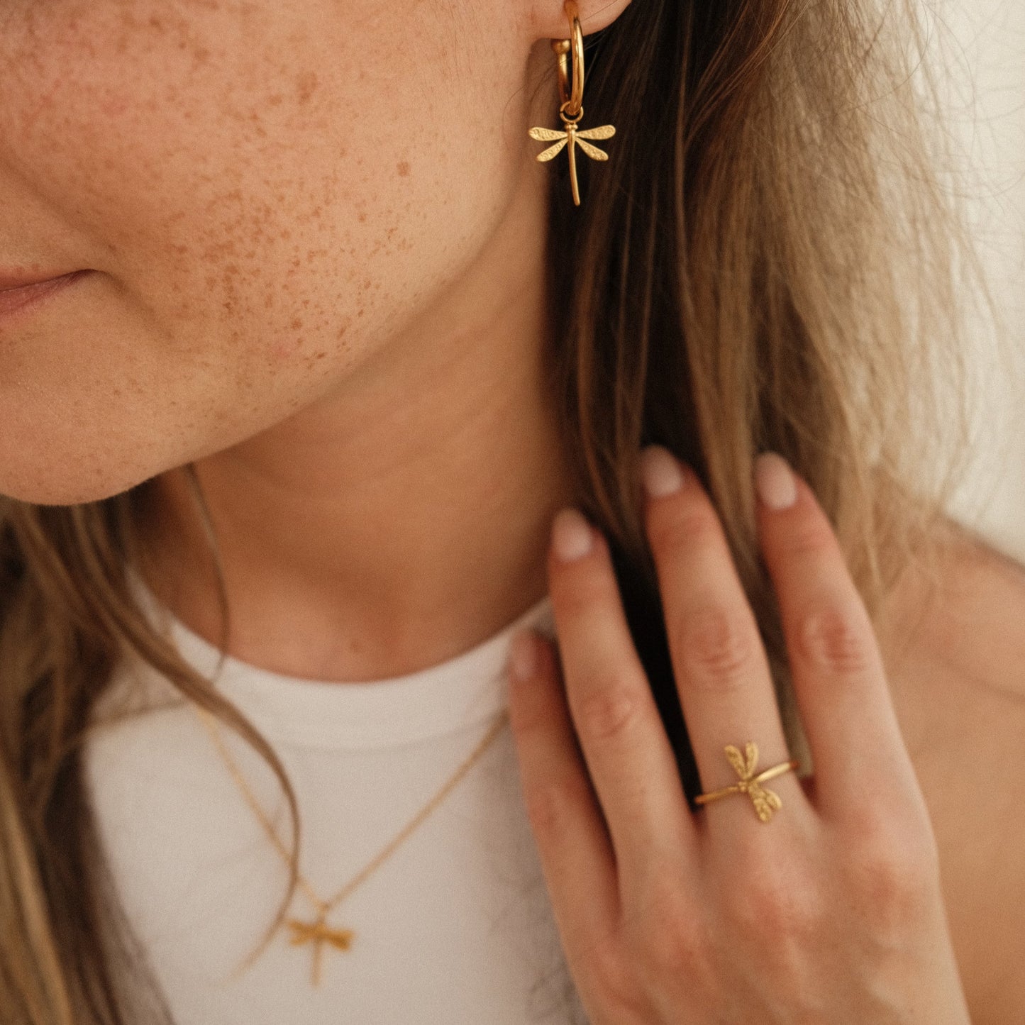 goldene Libellen Ohrringe am Model